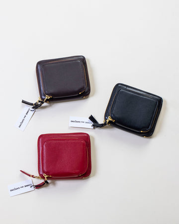 comme des garçons outside pocket zip around wallet • colors: brown, black & red • smooth leather • zip around closure on wallet out outside pocket • gold toned hardware  • 5